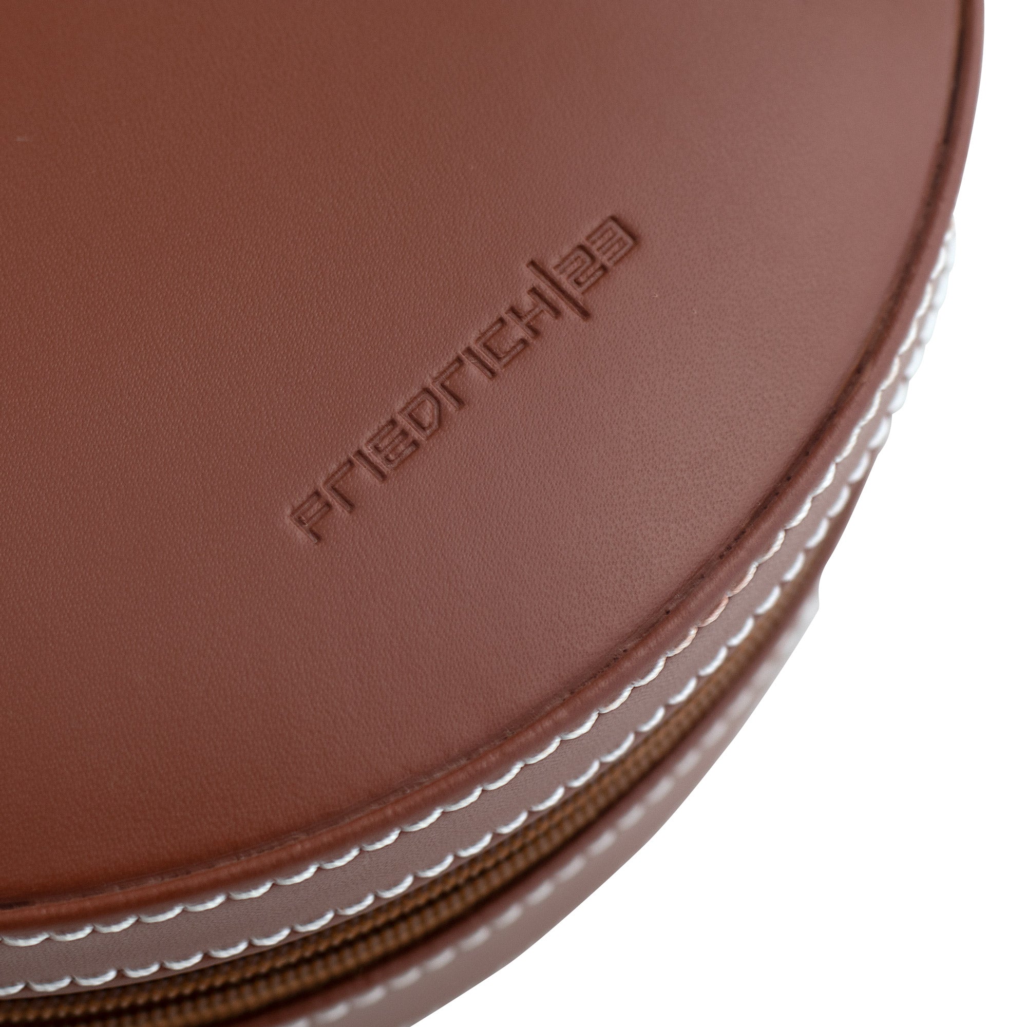 Detailaufnahme rundes Schmucketui aus Leder mit weißen Ziernähten und geprägtem Friedrich23 Logo