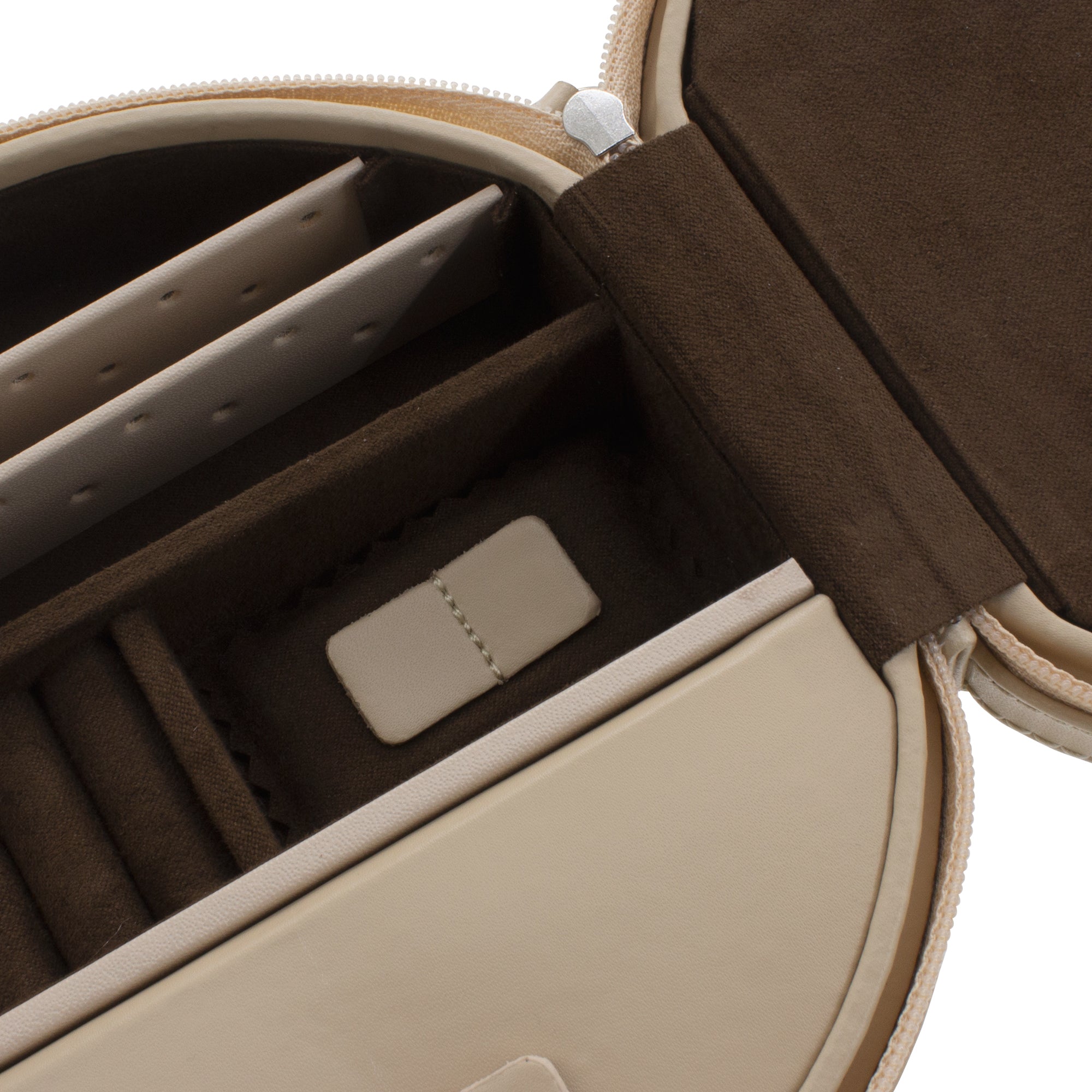 Detailansicht geöffnetes rundes Schmucketui aus Leder in beige mit unterteilten Fächern.