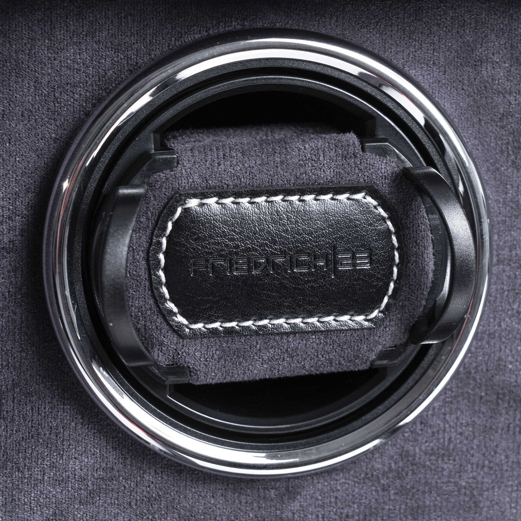 Detailansicht eines Uhrenbewegers aus schwarzem Leder mit grauem Velourstoff und geprägtem Friedrich23 Logo