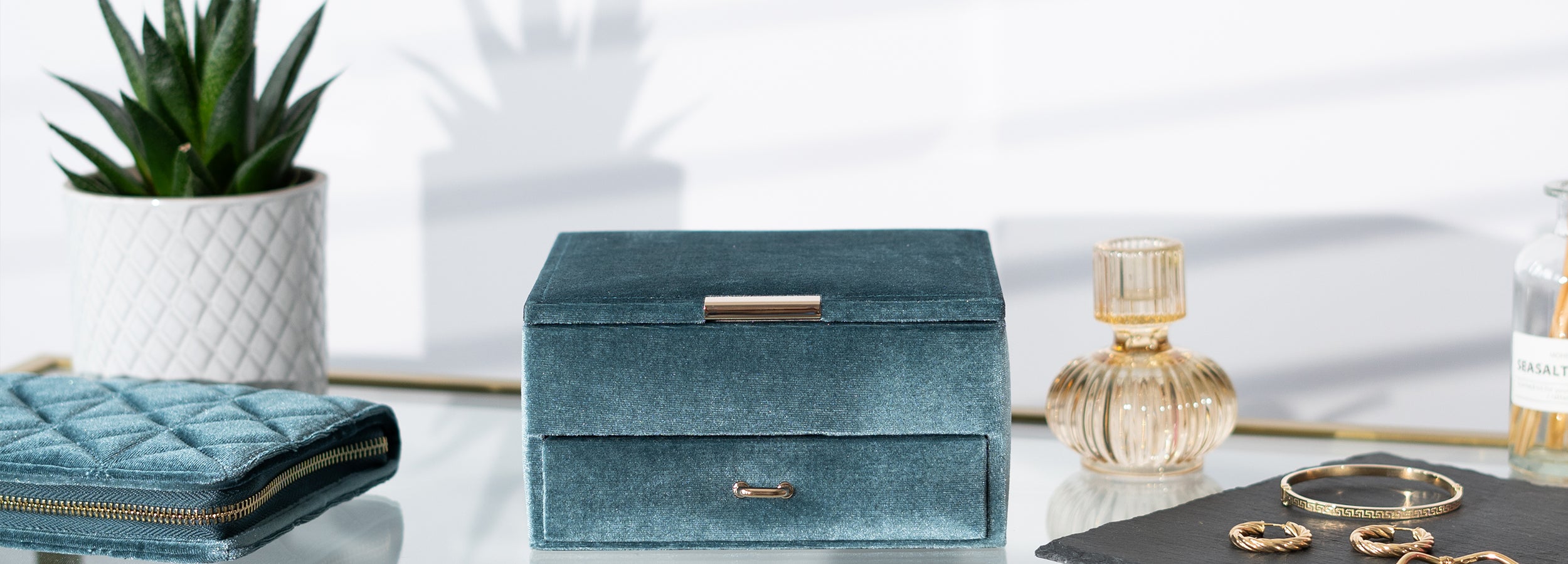 Schmuckkästchen und Schmuckreiseetui aus Samt mit. Schmuckkoffer mit Schublade und geschossenem Deckel mit Merall Applikation zum öffnen. Reiseschmucketui mit goldenem Reißverschluss und einer Steppnaht im Karo-Muster