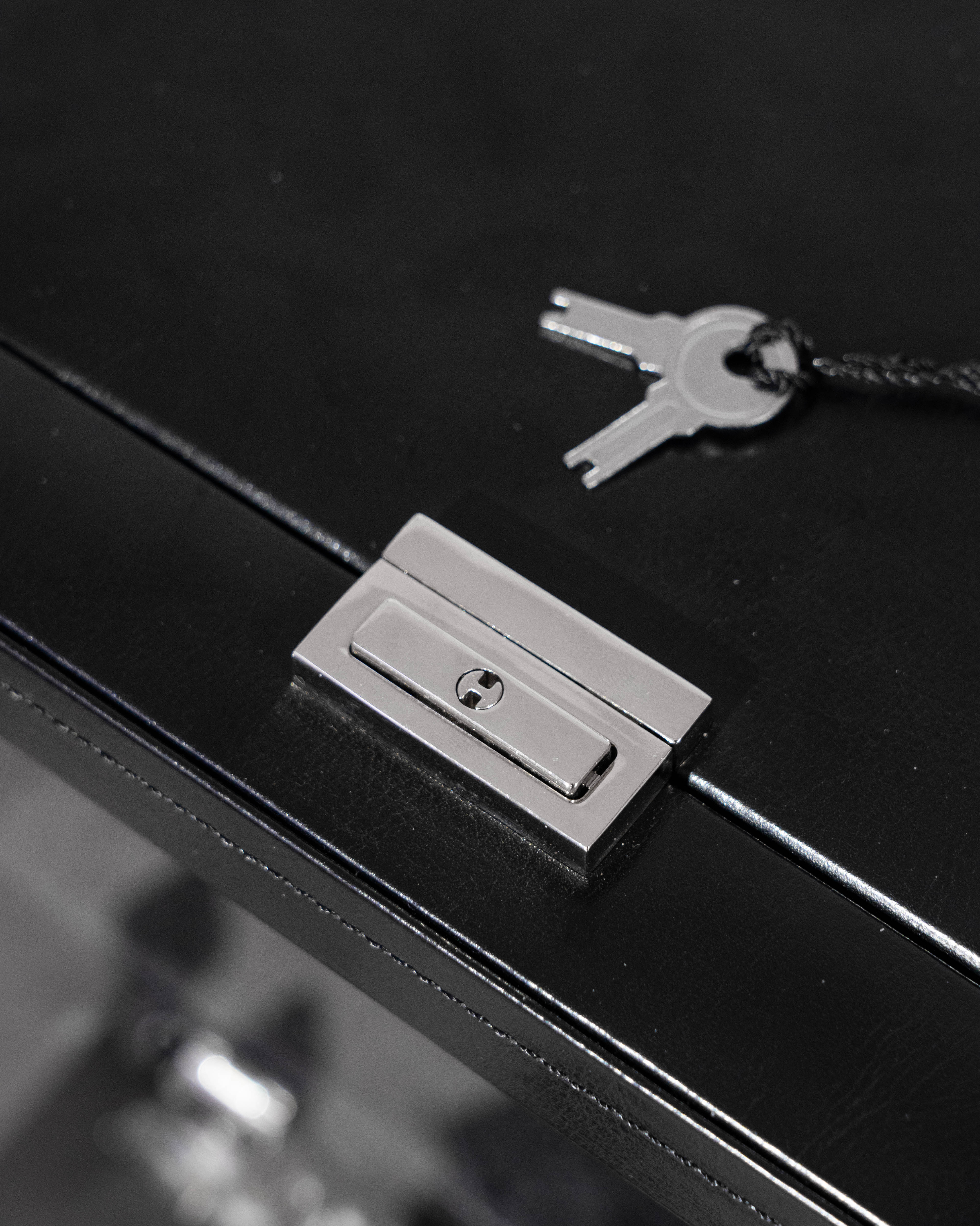 Silbernes Schloss plus Schlüssel von schwarzem Uhrenbeweger aus Leder