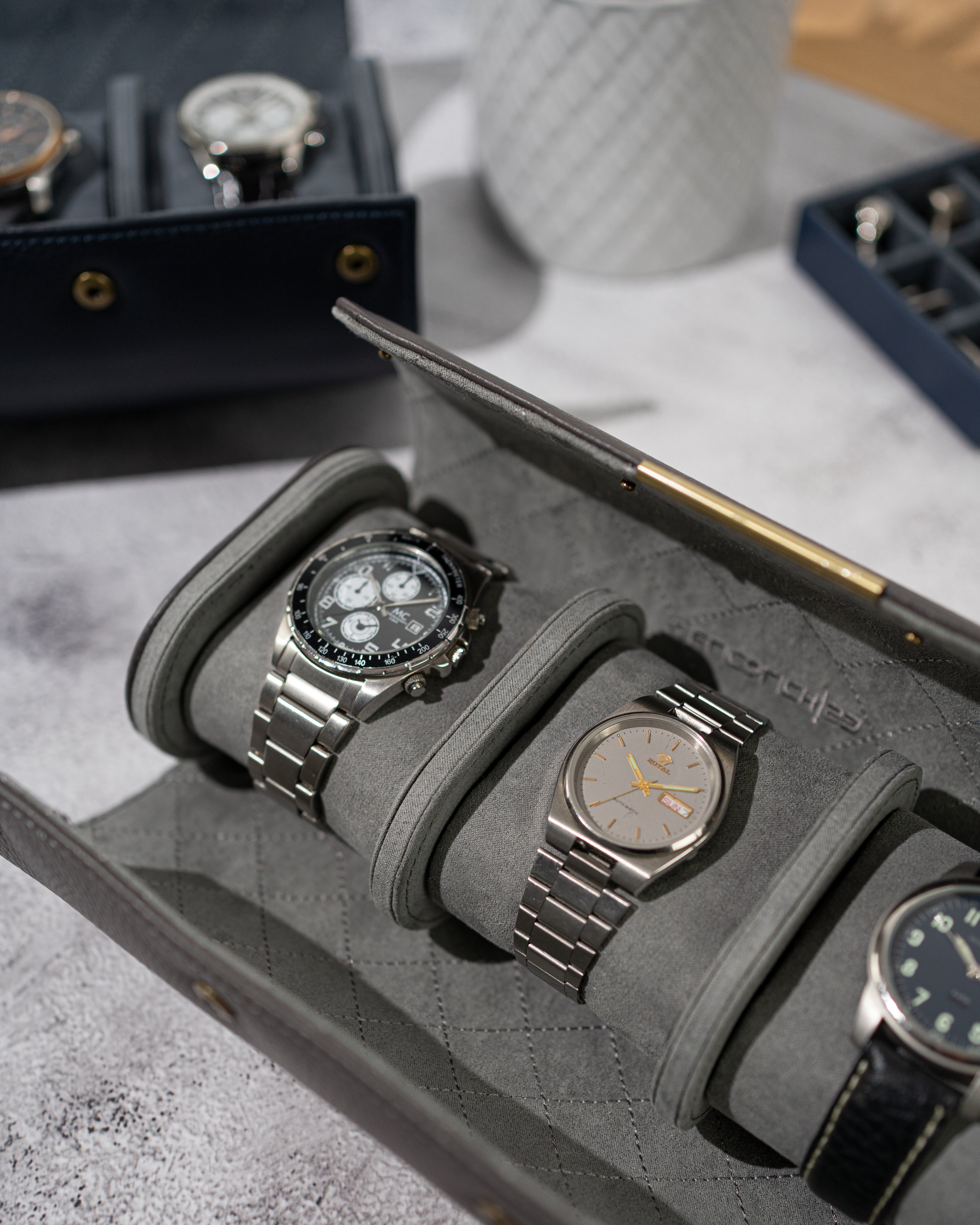 Nahaufnahme vom geöffnerter Uhrenrolle mit 3 Uhren auf Uhrenkissen aufgespannt.