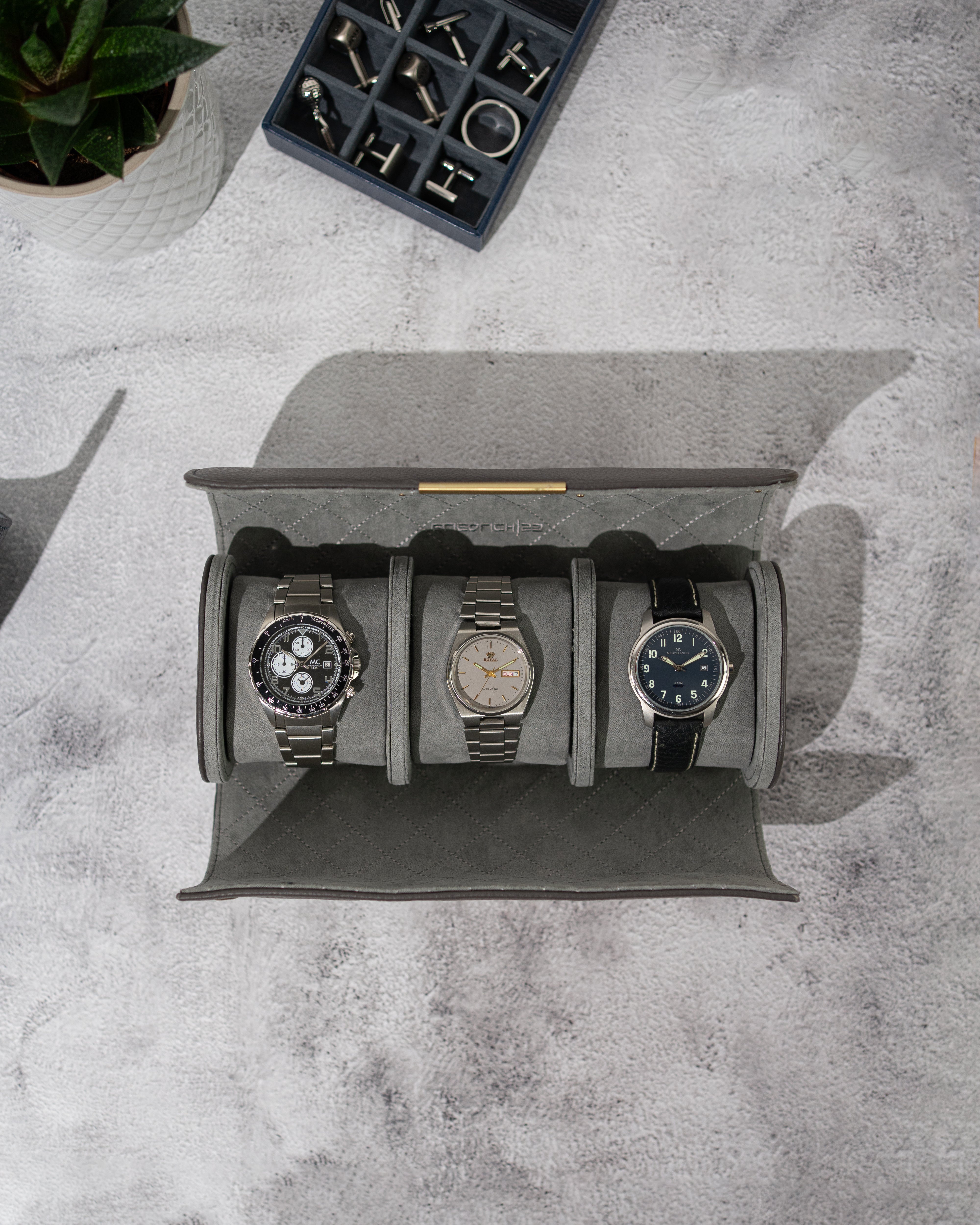 Graue Uhrenrolle von oben, geöffnert mit 3 Uhren auf Uhrenkissen befestigt