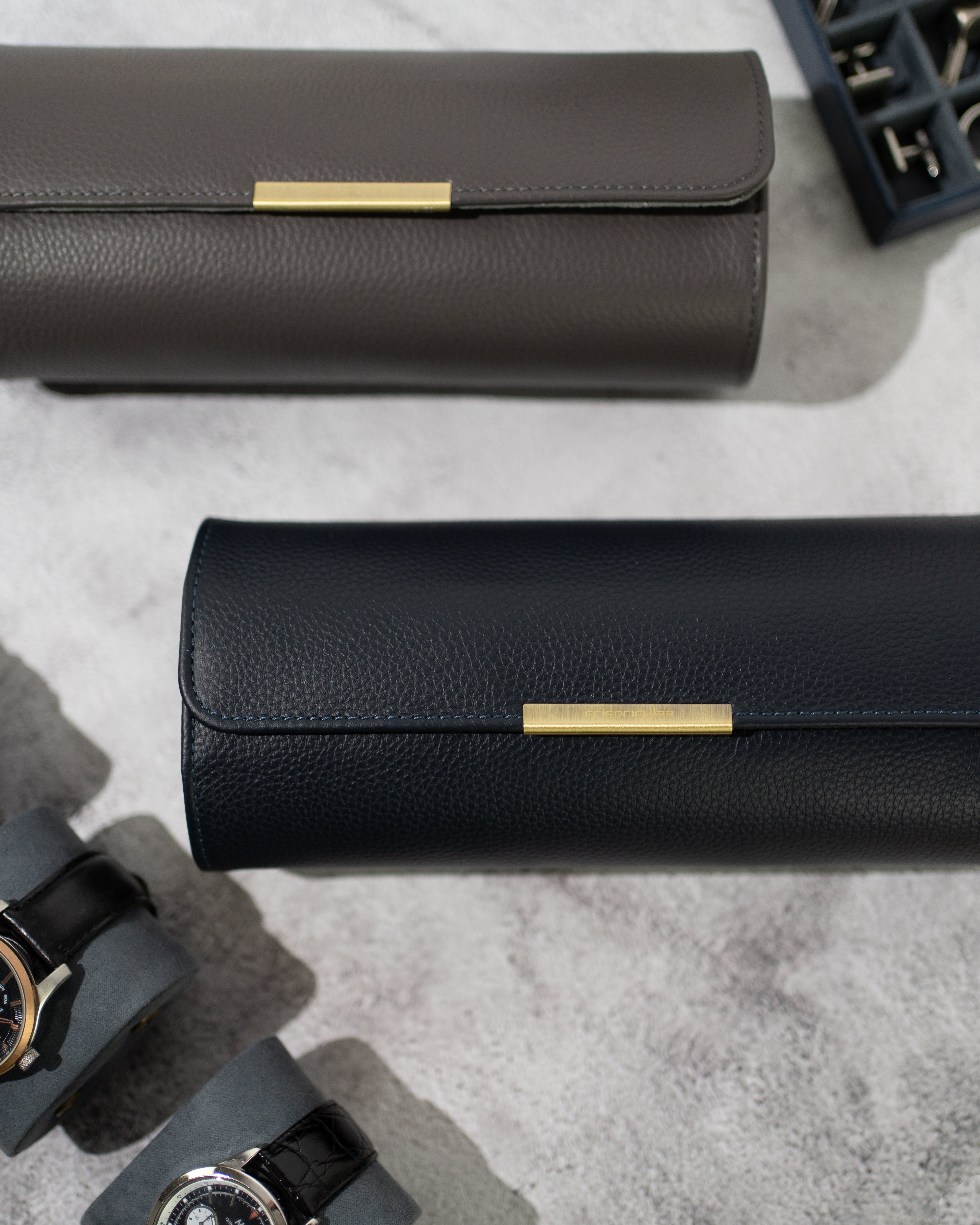 2 Uhrenrollen in Grau und Blau Nahaufnahme von genarbtem Leder und Metall Clip