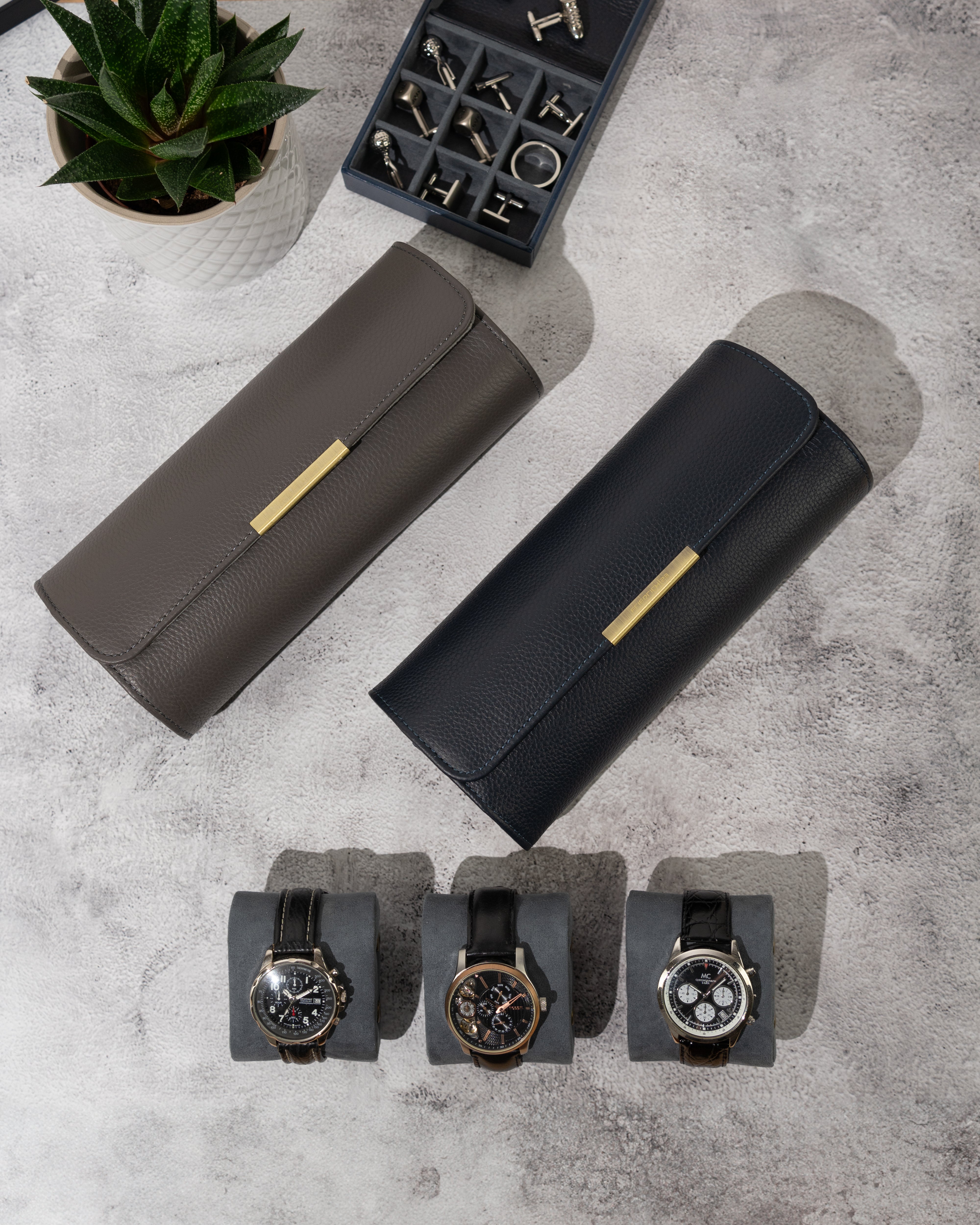 2 Uhrenrollen in Grau und Blau von oben, mit 3 Uhren auf Uhrenkissen