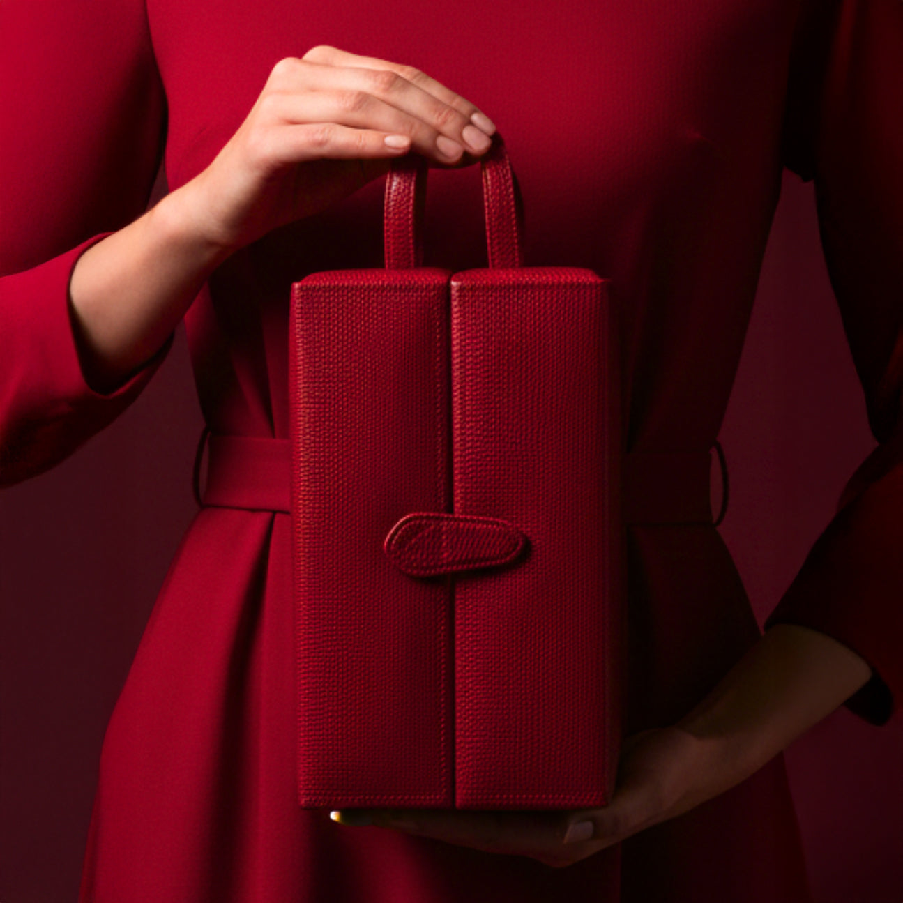 Roter Schmuckkasten in Turmform wird von einer Frau im roten Kleid gehalten