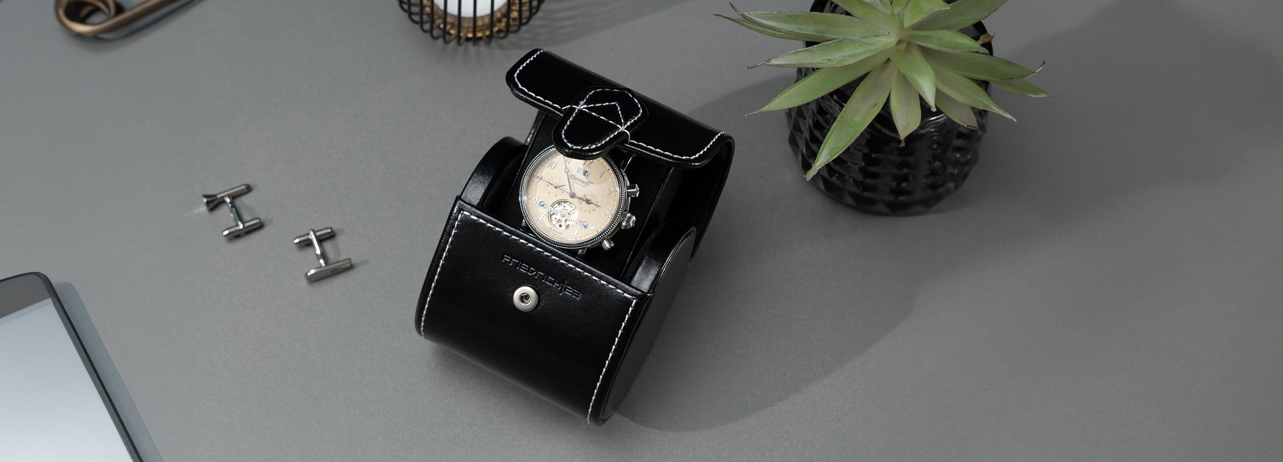 Geöffnetes schwarzes Uhrenetui mit Uhr und weißen Kontrastnähten – edle Aufbewahrung.