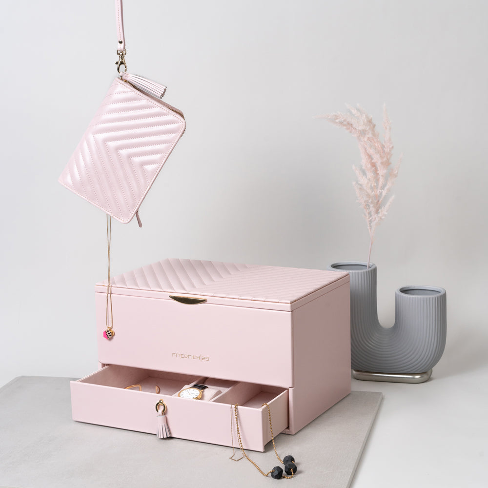 Großer Schmuckkasten mit offener Schublade, von oben hängt an einer Schlaufe ein Schmuck-Reisetui im Bild