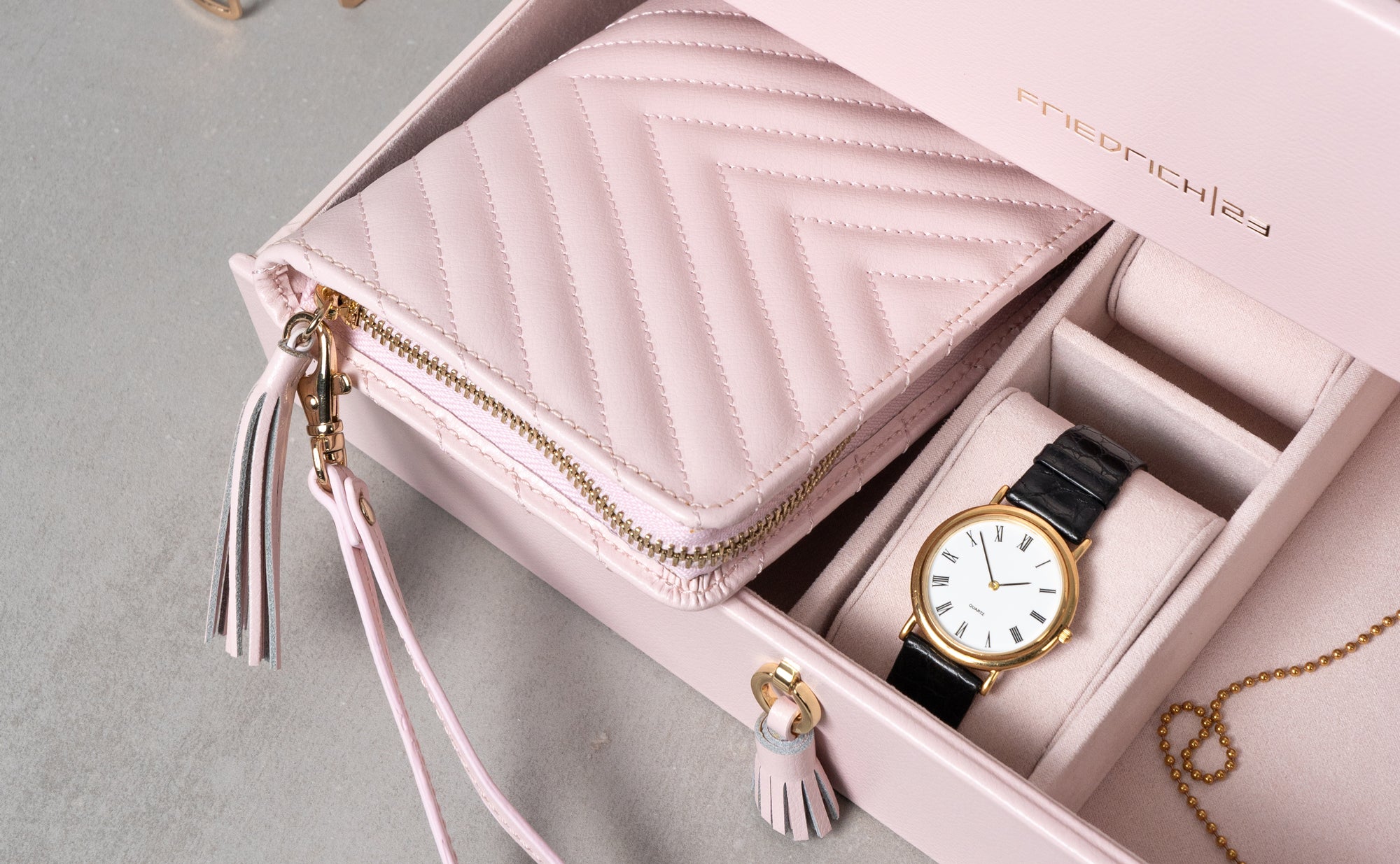 Reißverschluss-Schmucketui liegt passgenau in der Schublade, daneben eine Uhr auf dem Uhrenkissen