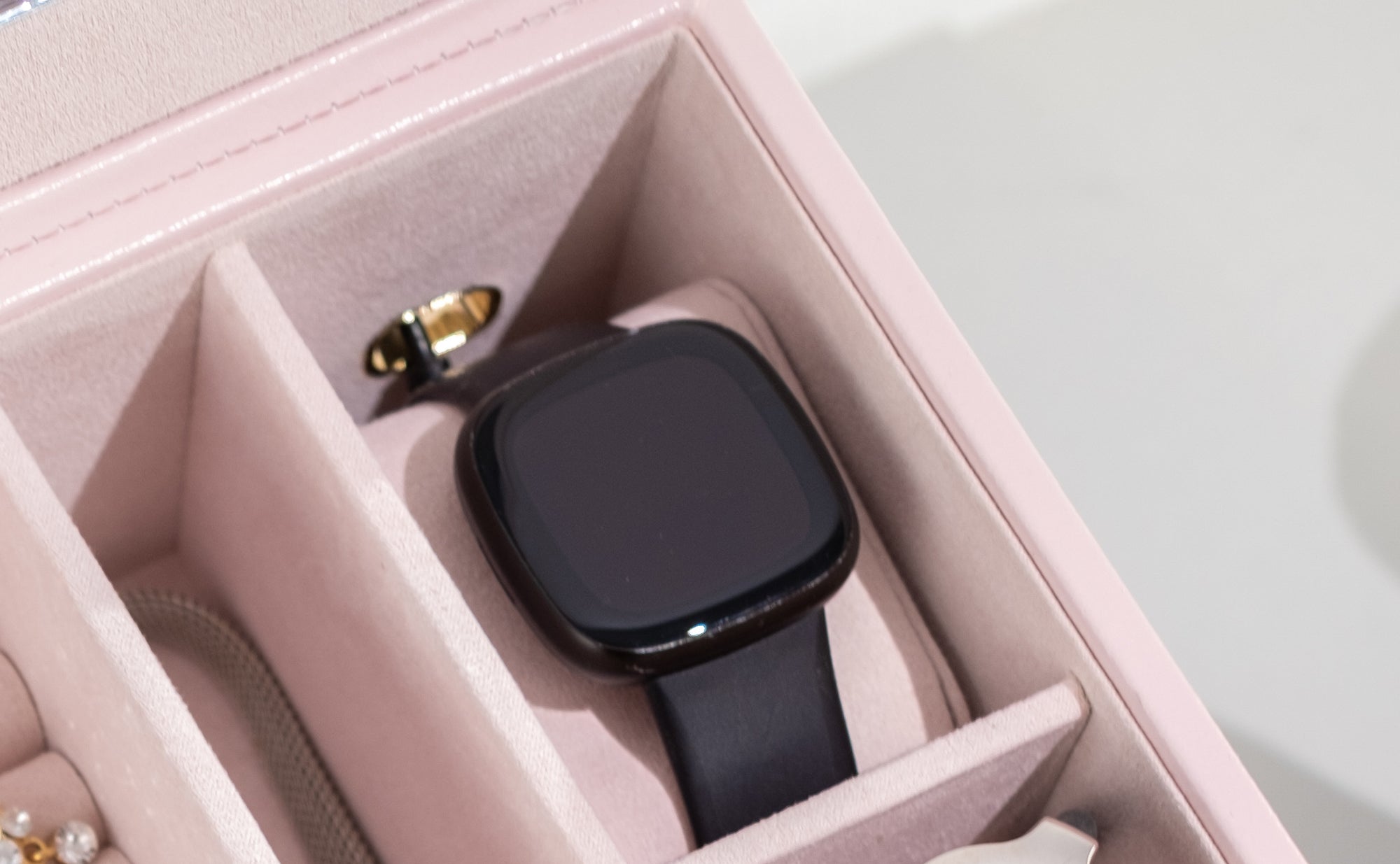 Smartwatch in einem extra Fach mit Öffnung für das Ladekabel